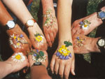 Bild vergrößert sich per Mausklick: Hände mit Blumenschmuck
